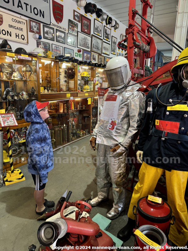 Mannequin demonstrating hazard protection clothing. This mannequin is wearing a Heat Resistant Aluminized Foil Refinery Proximity Suit. - Essex Fire Museum Living Mannequin Wearing A Heat Resistant Aluminized Foil Refinery Proximity Suit Mannequin demonstrating hazard protection clothing. This mannequin is wearing a Heat Resistant Aluminized Foil Refinery Proximity Suit. - Essex Fire Museum Living Mannequin Wearing A Heat Resistant Aluminized Foil Refinery Proximity Suit