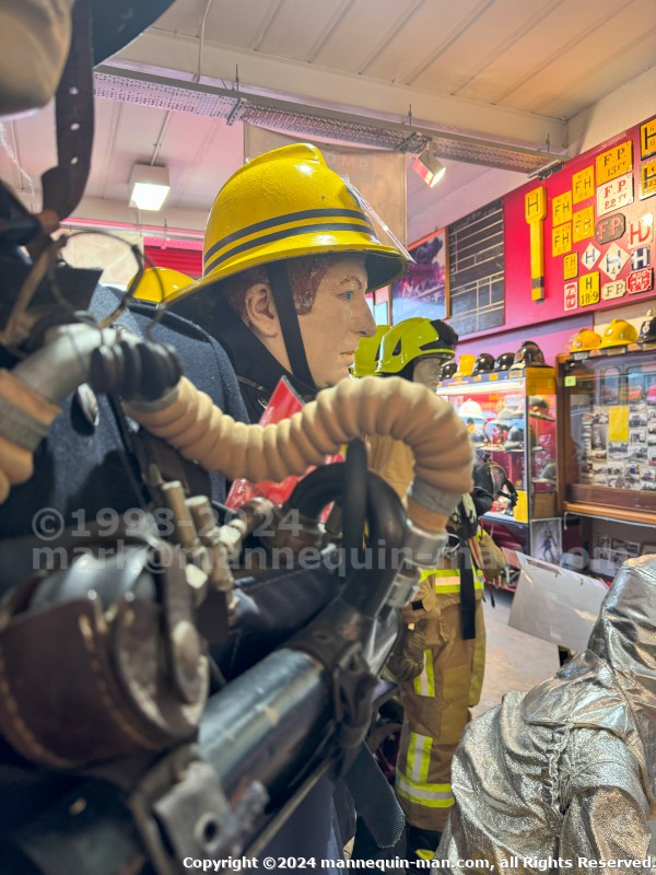 Mannequin wearing a 1976 Nomex jacket, yellow cork helmet and classic yellow PVC leggings. - Iconic 1970s Firemans Uniform With Yellow Yellow Waterproof Overtrousers And Yellow Cork Helmet With Blue Nomex Fire Tunic Mannequin wearing a 1976 Nomex jacket, yellow cork helmet and classic yellow PVC leggings. - Iconic 1970s Firemans Uniform With Yellow Yellow Waterproof Overtrousers And Yellow Cork Helmet With Blue Nomex Fire Tunic
