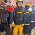 Iconic 1970s Firemans Uniform With Yellow Yellow Waterproof Overtrousers And Yellow Cork Helmet With Blue Nomex Fire Tunic mannequin-man performming as a Museum Dummy: Mannequin wearing a 1976 Nomex jacket, yellow cork helmet and classic yellow PVC leggings. for Essex Fire Museum on 26/11/2023