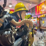 Iconic 1970s Firemans Uniform With Yellow Yellow Waterproof Overtrousers And Yellow Cork Helmet With Blue Nomex Fire Tunic mannequin-man performming as a Museum Dummy: Mannequin wearing a 1976 Nomex jacket, yellow cork helmet and classic yellow PVC leggings. for Essex Fire Museum on 26/11/2023
