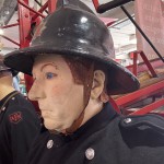 Living Mannequin Wearing 1950s Firefighter Uniform Black Helmet Yellow Leggings Essex Fire Museum mannequin-man performming as a Museum Dummy: Mannequin man wearing 1950-1960 firefighter uniform and breathing apparatus amusing the visitors for Essex Fire Museum on 26/05/2024