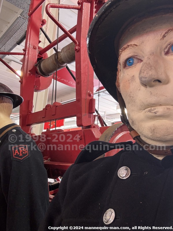 Mannequin man wearing 1950-1960 firefighter uniform and breathing apparatus amusing the visitors - Living Mannequin Wearing 1950s Firefighter Uniform Black Helmet Yellow Leggings Essex Fire Museum Mannequin man wearing 1950-1960 firefighter uniform and breathing apparatus amusing the visitors - Living Mannequin Wearing 1950s Firefighter Uniform Black Helmet Yellow Leggings Essex Fire Museum