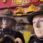 Living Mannequin Wearing 1950s Firefighter Uniform Black Helmet Yellow Leggings Essex Fire Museum mannequin-man performming as a Museum Dummy: Mannequin man wearing 1950-1960 firefighter uniform and breathing apparatus amusing the visitors for Essex Fire Museum on 26/05/2024