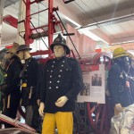 Living Mannequin Wearing 1950s Firefighter Uniform Black Helmet Yellow Leggings Essex Fire Museum mannequin-man performming as a Museum Dummy: Mannequin man wearing 1950-1960 firefighter uniform and breathing apparatus amusing the visitors for Essex Fire Museum on 26/05/2024